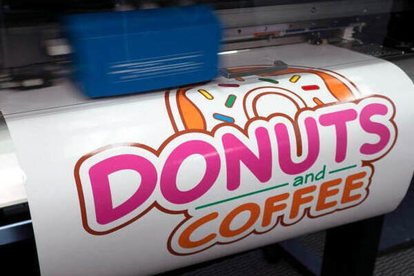 digital printing machine in cheez clothing factory making donut logo in pink color