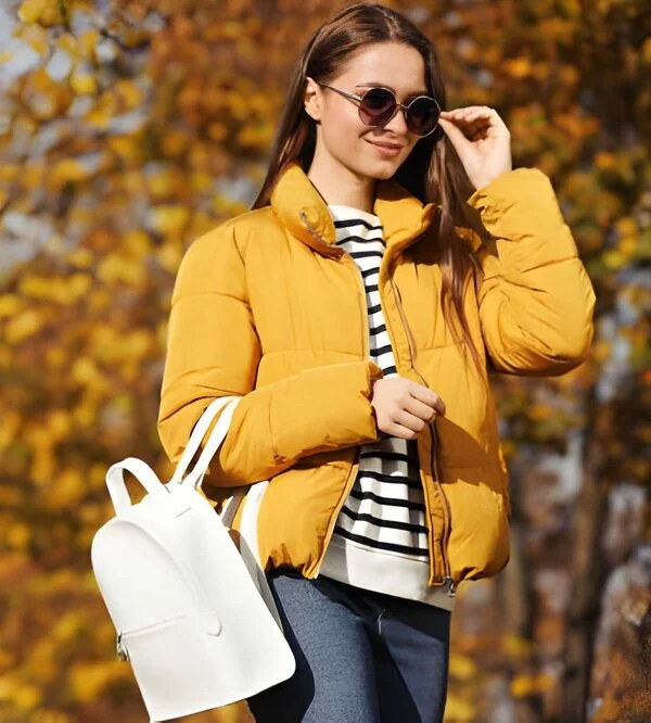 female wearing up a yellow puffer jacket. crafted by a British coat manufacturer. showcasing modern outwear design